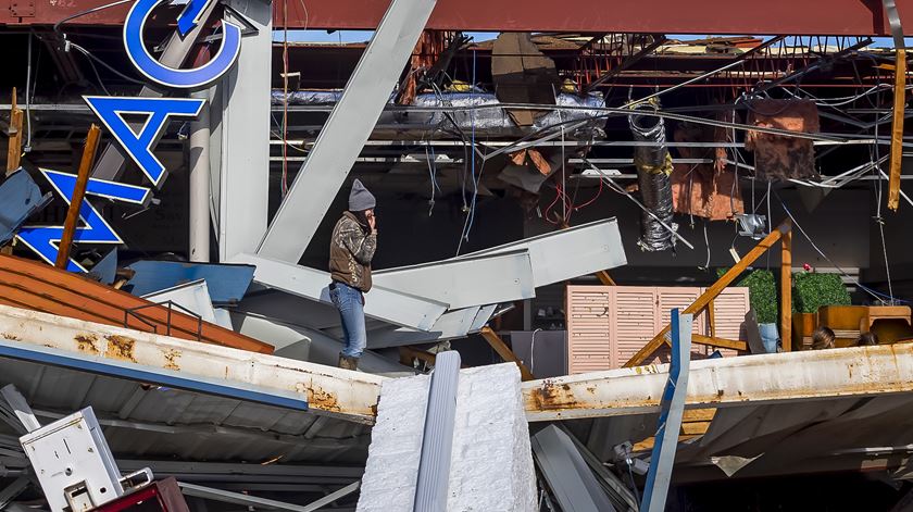 Armazém reduzido a um monte de escombros na cidade de Mayfield, no Kentucky. Foto: Addison Leboutillier/EPA (clique na seta para ver a fotogaleria)