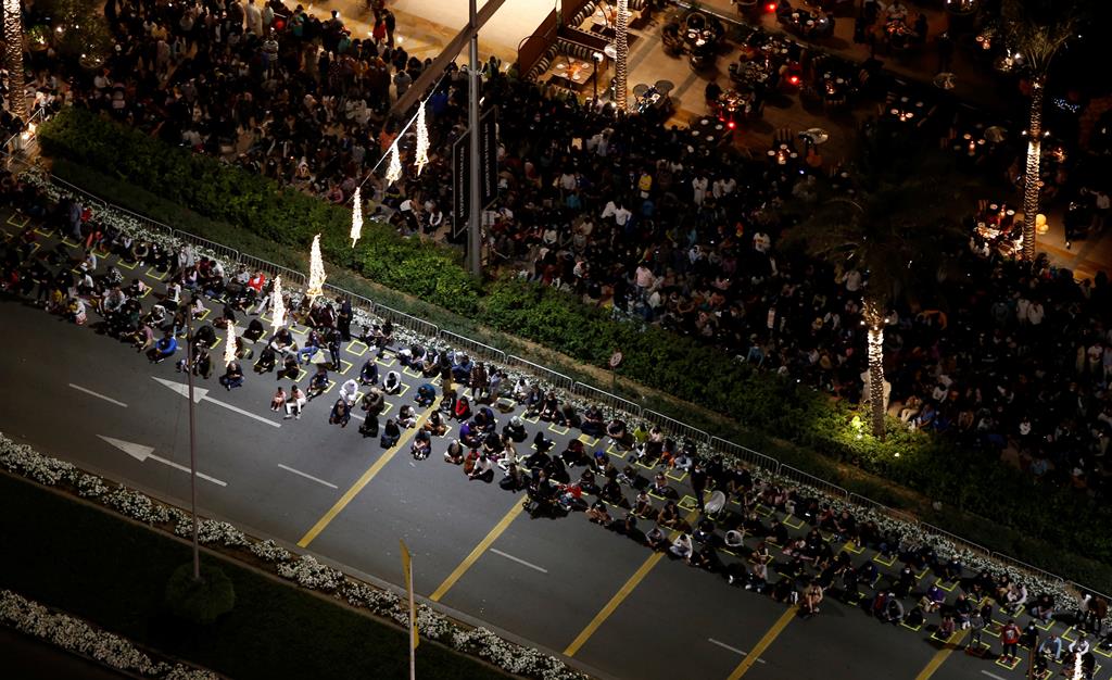 Pessoas reúnem-se junto ao Burj Khalifa, o edifício mais alto do mundo, para assistir ao espetáculo de fogo de artifício do ano novo, no Dubai. Foto: Ali Haider/EPA Pessoas reúnem-se junto ao Burj Khalifa, o edifício mais alto do mundo, para assistir ao espetáculo de fogo de artifício do ano novo, no Dubai. Foto: Ali Haider/EPA