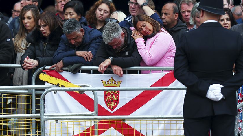 Populares ouvem a missa do funeral da rainha Isabel II no sistema de som pelas ruas de Londres, Inglaterra, Grã-Bretanha. Foto: Nuno Veiga/Lusa