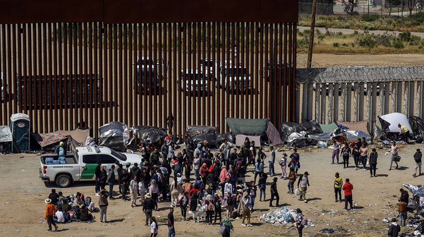 Migrants wait at the US-Mexico border. Foto: Joebeth Terriquez/EPA