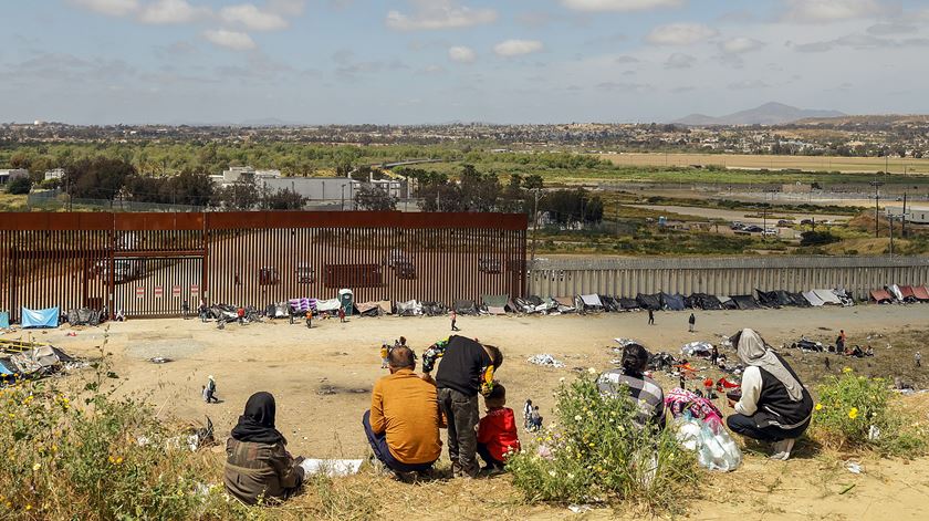 Migrants wait at the US-Mexico border. Foto: Joebeth Terriquez/EPA