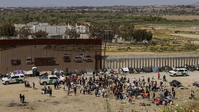 Migrants wait at the US-Mexico border. Foto: Joebeth Terriquez/EPA