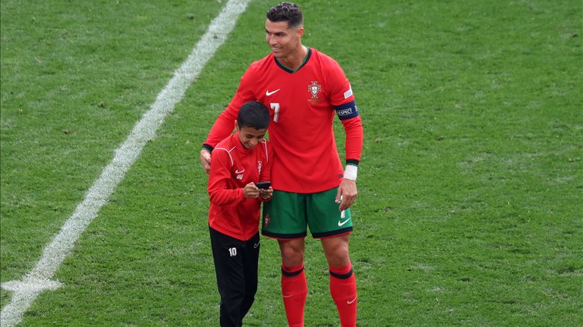 Criança invade jogo de Portugal com a Turquia para abraçar Cristiano Ronaldo. Foto: Christopher Neundorf/EPA