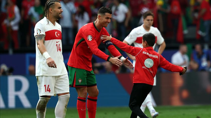 Criança invade jogo de Portugal com a Turquia para abraçar Cristiano Ronaldo. Foto: Friedemann Vogel/EPA