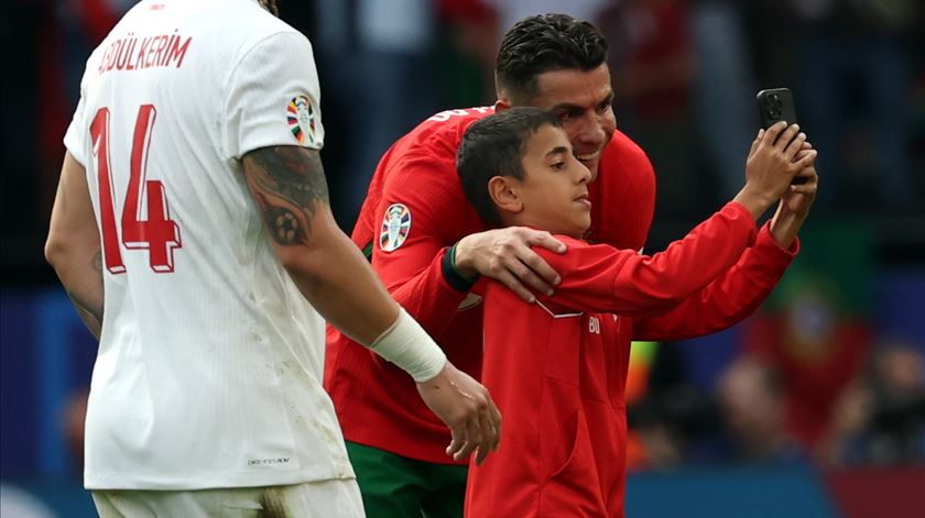 Criança invade jogo de Portugal com a Turquia para abraçar Cristiano Ronaldo. Foto: Friedemann Vogel/EPA