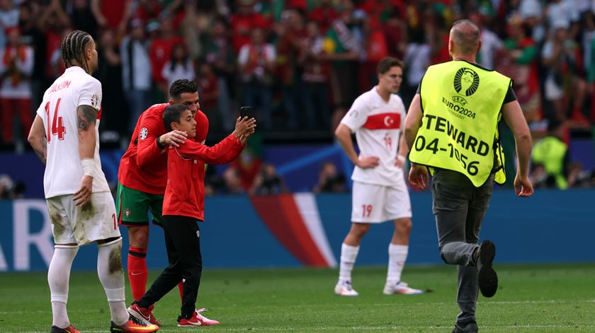 Criança invade jogo de Portugal com a Turquia para abraçar Cristiano Ronaldo. Foto: Friedemann Vogel/EPA