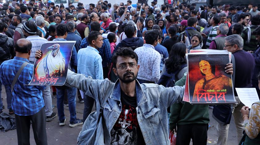 Ativistas indianos seguram cartazes e gritam palavras de ordem à porta do tribunal em Calcutá, em revolta com o caso de violação e assassinato de uma médica estagiária. Foto: Piyal Adhikary/EPA