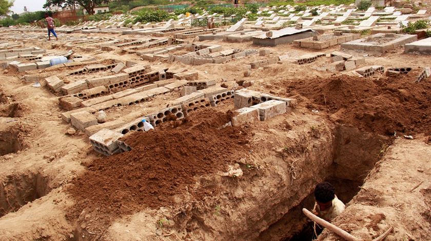 Trabalhadores cavam campas em Aden, no Iémen, para acolher os mortos da pandemia de Covid-19. Foto: Reuters