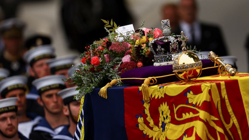 Em cima da urna seguem as joias da Coroa: coroa imperial, o orbe, o ceptro e o estandarte real. Um arranjo floral com flores colhidas dos jardins do Palácio de Buckingham, Clarence House e Highrove House, inclui elementos com especial significado. Segundo o the Guardian: o alecrim, que simboliza as memórias; murta, a flor que Isabel II usou no bouquet de casamento; e carvalho inglês, símbolo da força do amor. Foto: Reuters