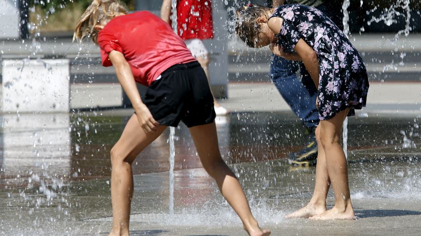 Pessoas refrescam-se junto a uma fonte, em Genebra, Suíça. Foto: Julien de Rosa/EPA