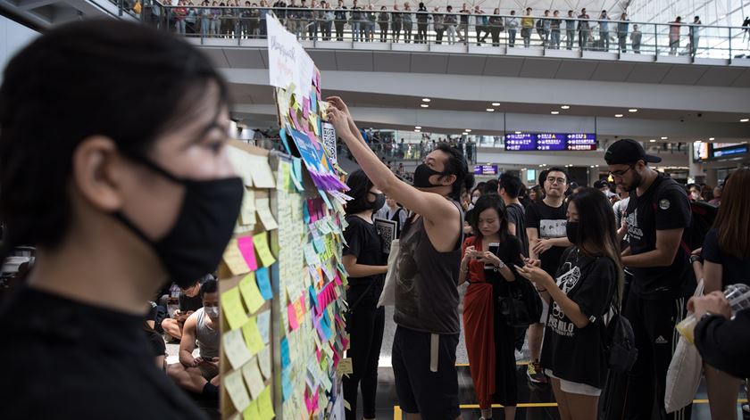 Manifestantes a colocar post-its na parede. Foto: Jerome Favre/EPA