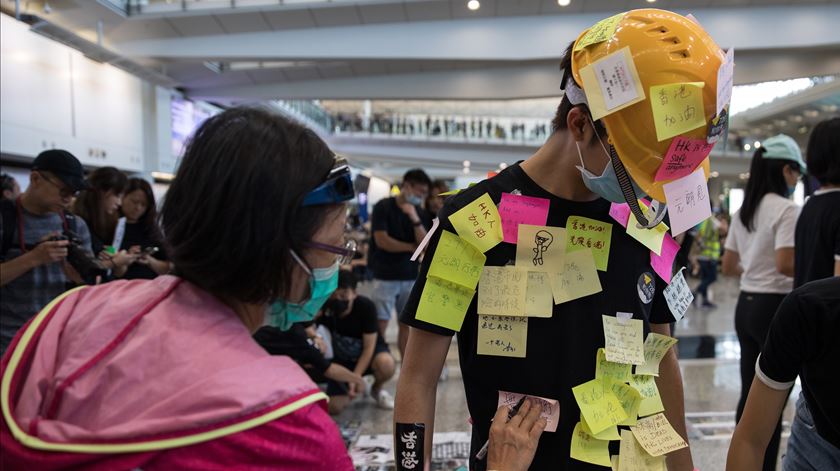 Manifestante cola post-its com mensagens de protesto. Foto: Jerome Favre/EPA