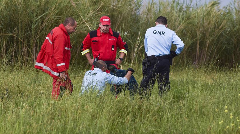 Um elemento da GNR segura uma peça de roupa durante as buscas para encontrar a criança de 9 anos. Foto: Carlos Barroso/ Lusa