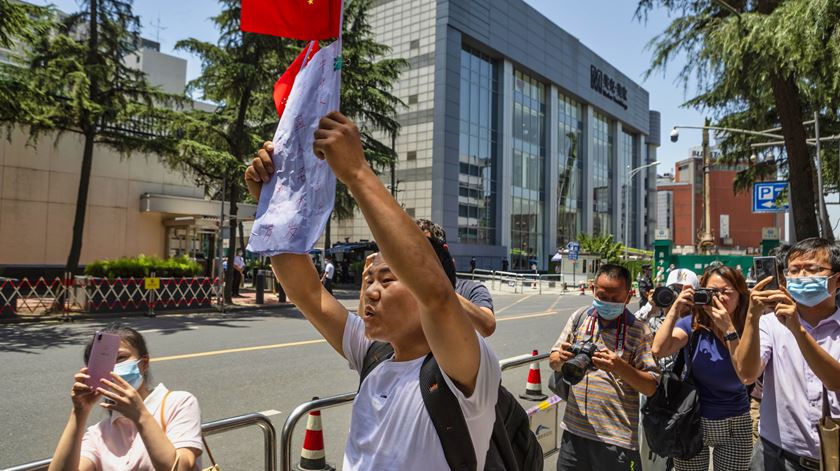Chineses foram para a rua empunhando bandeiras e a tirar "selfies" junto ao edifício do consulado. Foto: Alex Plavevski/EPA Chineses foram para a rua empunhando bandeiras e a tirar "selfies" junto ao edifício do consulado. Foto: Alex Plavevski/EPA