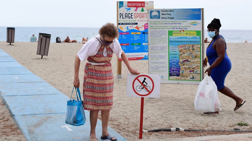 Veraneantes de máscara em praia de Argeles-sur-Mer, em França, cujo autarca ditou uso obrigatório de máscara e multas de 38 euros para quem não cumprir. Foto: Caroline Blumberg/EPA