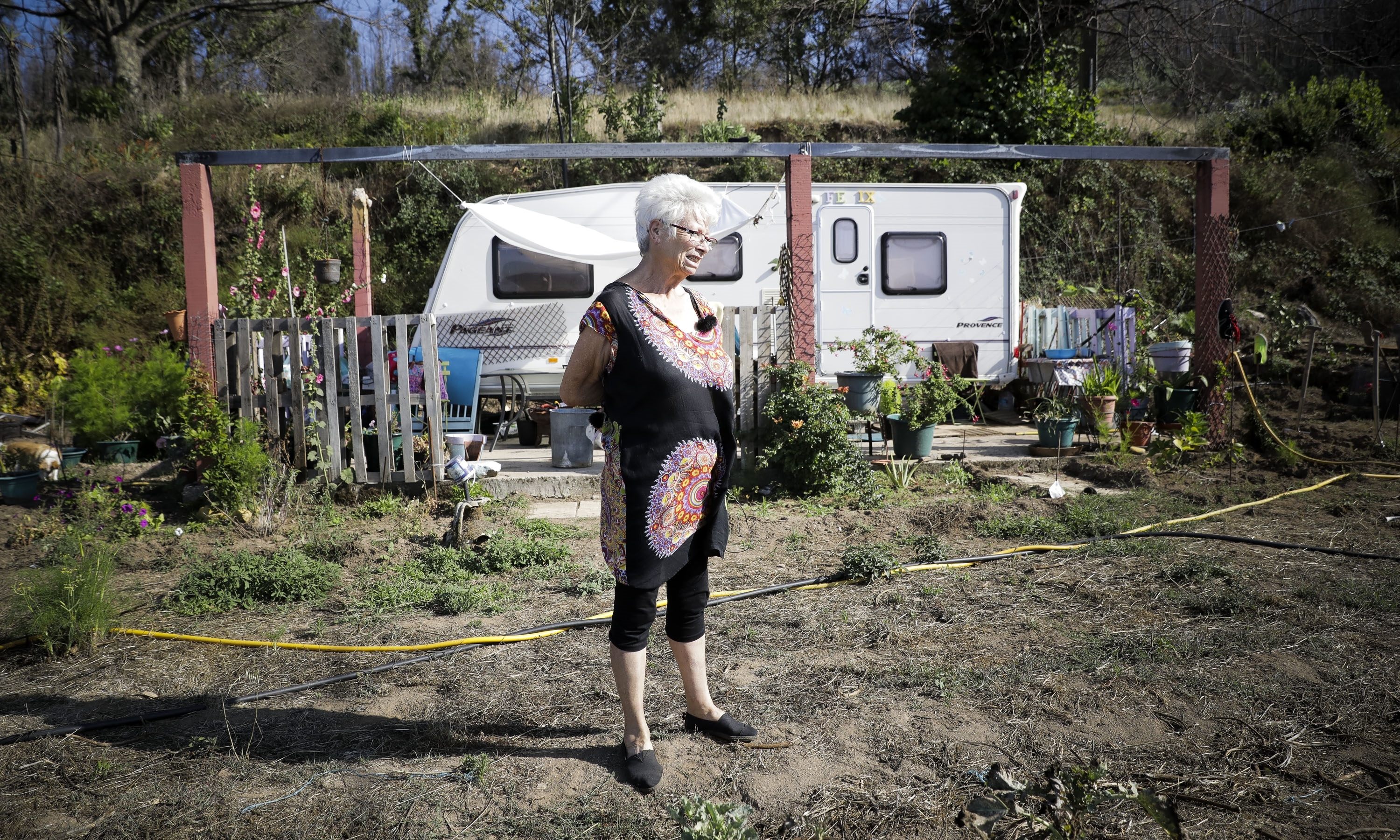 Evelyn vai todos os dias regar as flores que crescem espontaneamente no terreno onde antes estava a sua casa. Evelyn vai todos os dias regar as flores que crescem espontaneamente no terreno onde antes estava a sua casa.