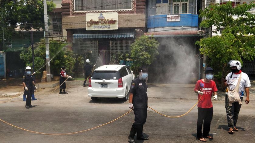 Funcionários estatais desinfetam rua de Mandalay, no Myanmar (antiga Birmânia). Foto: Saw Nang