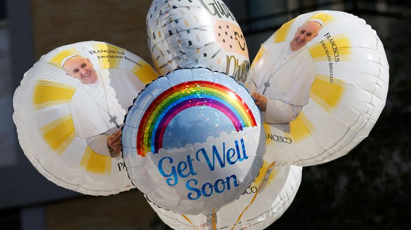 Balões com a imagem do Papa Francisco e desejos de rápidas melhoras foram vistos à porta da Clínica Gemelli, onde Francisco está hospitalizado. Foto: Ciro De Luca/Reuters