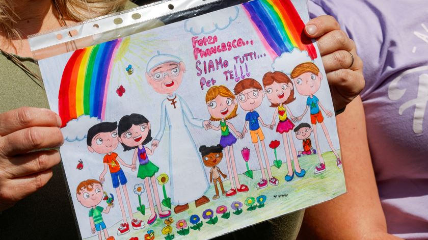 Uma pessoa mostra um desenho infantil onde o Papa Francisco aparece, à porta da Clínica Gemelli, onde Francisco está hospitalizado. Foto: Ciro De Luca/Reuters