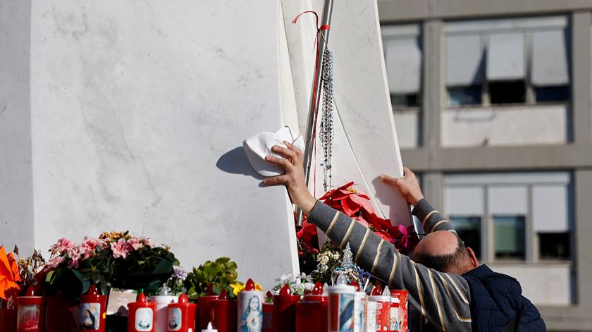 Homem reza junto à estátua de São João Paulo II, em frente à Clínica Gemelli, onde o Papa Francisco se encontra hospitalizado. Foto: Vincenzo Livieri/Reuters