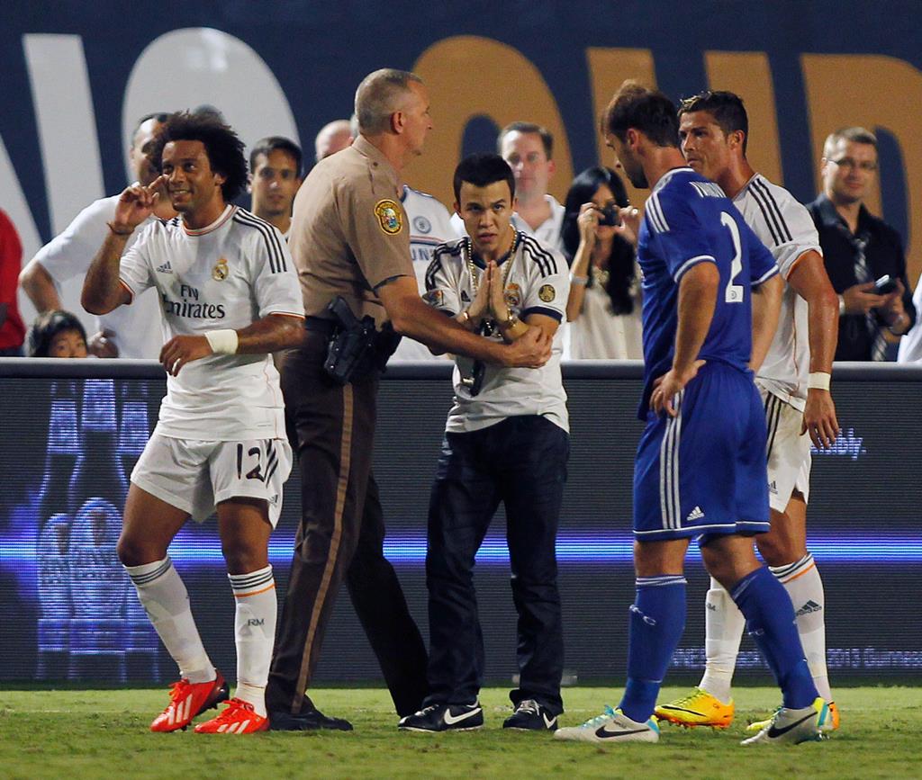 Ronald Gjoka, no momento da detenção, enquanto pede desculpa a Ivanovic, do Chelsea, por ter interrompido o jogo. Ronald Gjoka, no momento da detenção, enquanto pede desculpa a Ivanovic, do Chelsea, por ter interrompido o jogo.